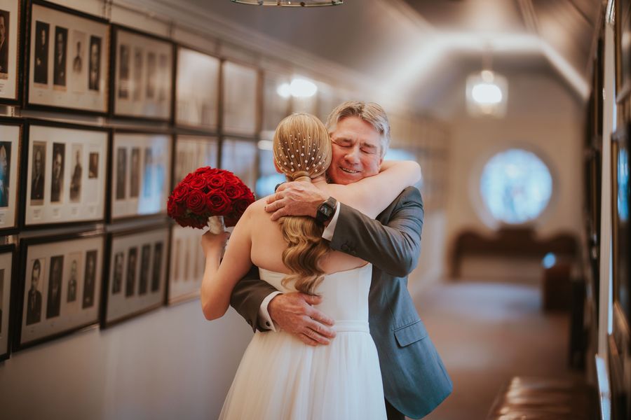 Father embracing bride at wedding